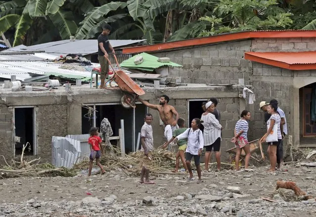 Residents clear up debris from around their houses following a flood in Dili, East Timor, Monday, April 5, 2021. (Photo by Kandhi Barnez/AP Photo)