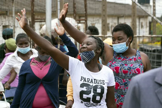 Female prsioners wave goodbye to their fellow inmates following their release from Chikurubi prison on the outskirts of Harare, Saturday, April 17, 2021. Zimbabwe began the release of about 3,000 prisoners under a presidential amnesty aimed at easing congestion and minimizing the threat of COVID-19 across the country's overcrowded jails. (Photo by Tsvangirayi Mukwazhi/AP Photo)