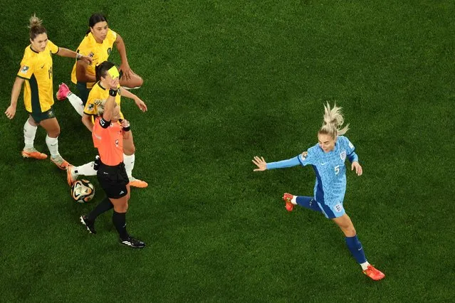 England's defender #05 Alex Greenwood (R) receives a yellow card from referee Tori Penso during the Australia and New Zealand 2023 Women's World Cup semi-final football match between Australia and England at Stadium Australia in Sydney on August 16, 2023. (Photo by David Gray/AFP Photo)