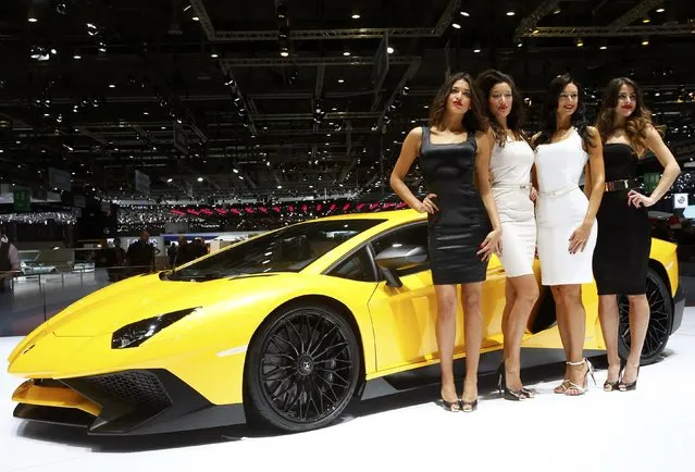 Models pose next to a Lamborghini Aventador SV sports car during the second press day ahead of the 85th International Motor Show in Geneva March 4, 2015. REUTERS/Arnd Wiegmann