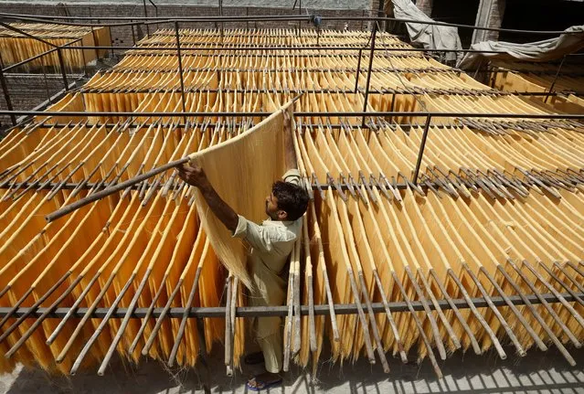 A vendor arranges traditional vermicelli noodles, which is most favorite during the Muslim's holy fasting month of Ramadan, at a factory, in Lahore, Pakistan, Tuesday, April 27, 2021. (Photo by K.M. Chaudary/AP Photo)