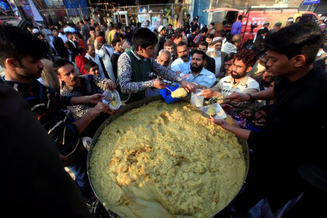 Men distribute halwa among participants taking part in a procession to celebrate Eid-e-Milad-ul-Nabi, the birthday anniversary of Prophet Mohammad, in Rawalpindi, Pakistan December 12, 2016. (Photo by Faisal Mahmood/Reuters)