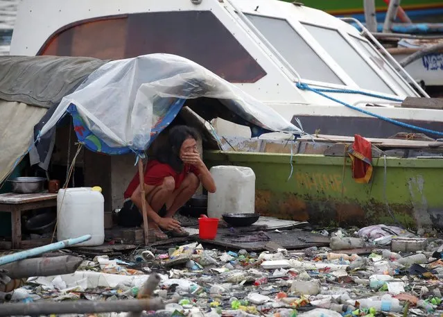 A Filipino informal settler living on a makeshift shelter is seen along the Manila Bay, Philippines, 11 June 2021. According to a report published in the Science Advances journal, rivers in the Philippines contribute tons of plastic waste which are funneled through Manila Bay to the world's oceans annually. (Photo by Francis R. Malasig/EPA/EFE)