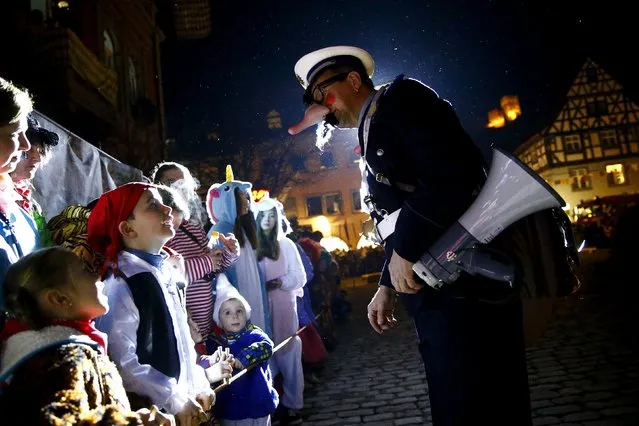 Two comedians dressed as policemen inform visitors about the traditional “witches sabbath” carnival performance of the Kandel-witches (Kandelhexen) in the Black Forest village of Waldkirch, Germany, February 6, 2016. (Photo by Kai Pfaffenbach/Reuters)