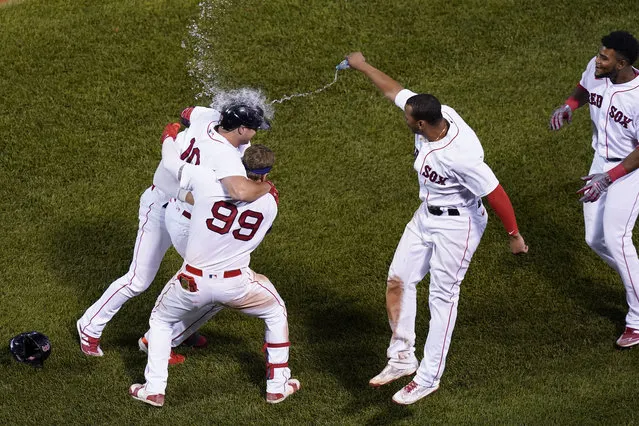 Boston Red Sox's Hunter Renfroe (10) is congratulated after he drove in the winning run with a sacrifice fly in the 10th inning of the team's baseball game against the New York Yankees at Fenway Park, Thursday, July 22, 2021, in Boston. The Red Sox won 5-4. (Photo by Elise Amendola/AP Photo)