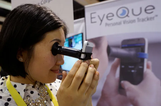 Phoebe Yu of Eyeque Corp., demonstrates her EyeQue Personal Vision Tracker vision testing device attached to a smart phone at CES in Las Vegas, January 3, 2017. (Photo by Rick Wilking/Reuters)
