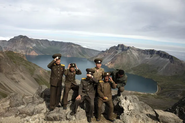 North Korean soldiers adjust their hats before posing for a photo on a viewing platform overlooking the caldera of Mount Paektu in North Korea, on Saturday, August 18, 2018. (Photo by Ng Han Guan/AP Photo)