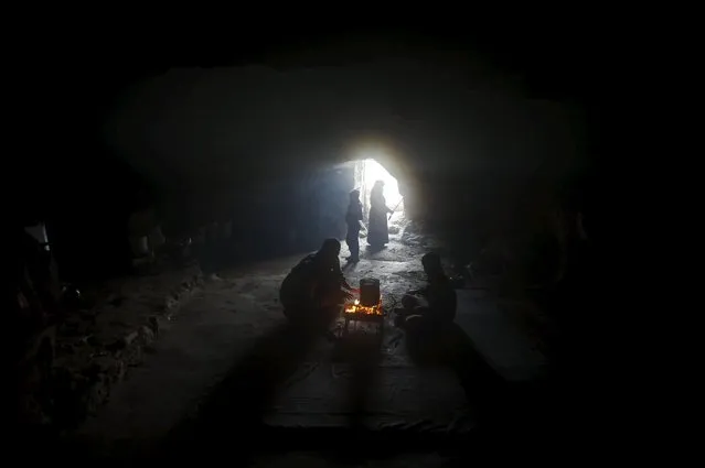 Palestinians warm themselves by a fire inside a cave they live in, during a snow storm in West Bank village of Mufagara, south of Hebron January 27, 2016. (Photo by Mussa Qawasma/Reuters)