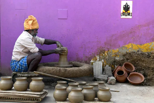 An Indian potter makes earthen pots for sale ahead of the Hindu Pongal festival, or Makar Sankranti, in a village on the outskirts of Chennai on January 8, 2019. Hindus use earthern pots to cook as a part of rituals during the celebration of the Pongal harvest festival that is celebrated each year in January. (Photo by Arun Sankar/AFP Photo)