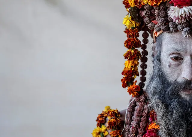 A Naga Sadhu or Hindu holy man waits for devotees inside his camp during “Kumbh Mela” or the Pitcher Festival, in Prayagraj, previously known as Allahabad, India January 17, 2019. (Photo by Danish Siddiqui/Reuters)