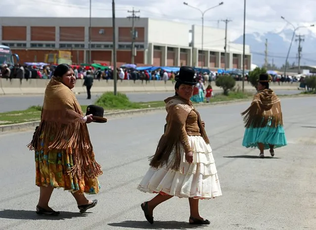 Aymara women walk on a highway as the city celebrates the 31st anniversary of its foundation in El Alto, on the outskirts of La Paz March 6, 2016. (Photo by David Mercado/Reuters)