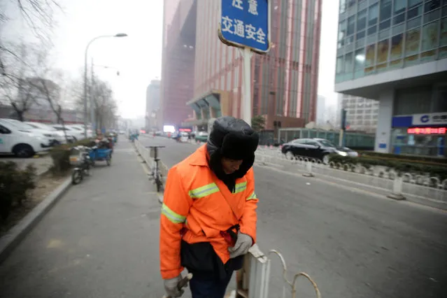 A cleaner walks along a street in Beijing's central business area, China, January 17, 2017. (Photo by Jason Lee/Reuters)