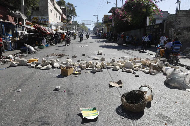 A streets is blocked with stones and debris placed there by protesters to call attention to the country's insecurity and demanding the resignation of the prime minister, in Port-au-Prince, Haiti, Thursday, January 18, 2024. (Photo by Odelyn Joseph/AP Photo)