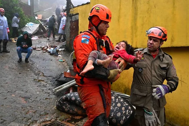 Members of the Civil Defense carry a girl, who remained more than 12 hours under the rubble of her house, which was destroyed by the heavy rains in Petropolis, Brazil on March 23, 2024. At least nine people died in the midst of a strong storm that hits the southeast of Brazil, particularly the mountain area of the state of Rio de Janeiro, where authorities deployed a strong operation this Saturday in the face of a "critical" situation. The authorities reported three deaths in the collapse of a house in the city of Petropolis, about 70 kilometers from the capital of Rio, in a bulletin issued by an emergency committee formed by the government of Rio together with the Fire and Defense forces. (Photo by Pablo Porciuncula/AFP Photo)