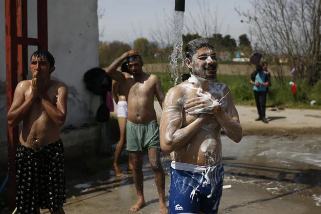 Migrants from Pakistan take a bath before Friday prayer at a makeshift camp for migrants and refugees at the Greek-Macedonian border near the village of Idomeni, Greece, April 1, 2016. (Photo by Marko Djurica/Reuters)
