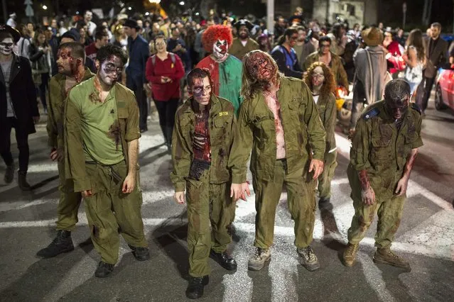 Israelis costumed as zombie soldiers take part in the annual “Zombie Walk” for the Jewish holiday of Purim in Tel Aviv, on March 17, 2014. (Photo by Amir Cohen/Reuters)