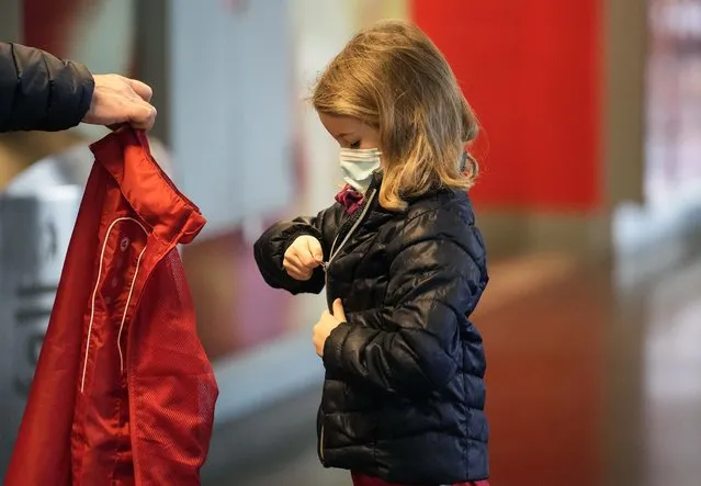 6-year old kid Lotte puts on her jacket after she received her second coronavirus vaccination against the COVID-19 disease at the Laxness-Arena in Cologne, Germany, Friday, January 7, 2022 where all  participating children were rewarded for their vaccination. (Photo by Martin Meissner/AP Photo)