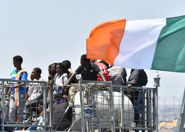 Migrants wait to be disembarked from the Irish Navy ship P31 L.E. Eithne at the Catania harbor, Italy, Tuesday, June 16, 2015. European Union nations failed to bridge differences Tuesday over an emergency plan to share the burden of the thousands of refugees crossing the Mediterranean, while on the French-Italian border, police in riot gear forcibly removed dozens of migrants. (AP Photo/Carmelo Imbesi)