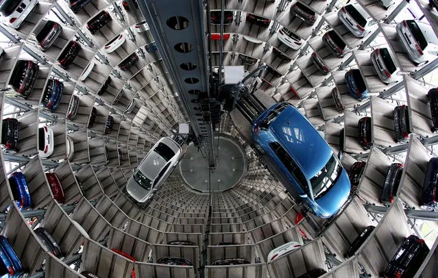 A new e-Golf vehicle (R) and a Passat (L) of German car maker Volkswagen are seen in one of the twin car towers at the Volkswagen factory during a visit on the sidelines of the company's annual press conference on April 28, 2016 in Wolfsburg, northern Germany. Embattled German carmaker Volkswagen vowed to overcome its current crisis triggered by the engine-rigging scandal, insisting it would not allow itself to be slowed down by the affair and would drive back to profit this year. (Photo by Ronny Hartmann/AFP Photo)