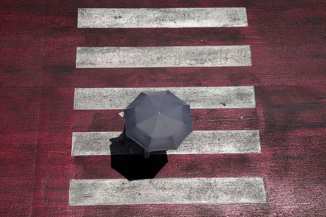A pedestrian holds an umbrella to protect from the sun in Bangkok, Thailand, Friday, May 3, 2024. (Photo by Sakchai Lalit/AP Photo)