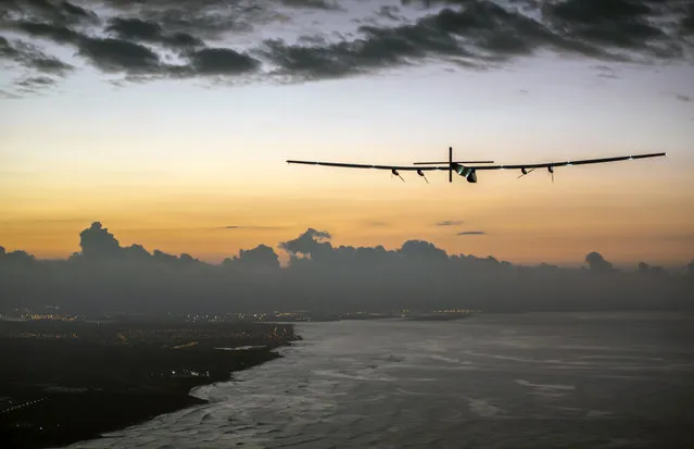 Solar Impulse 2, a plane powered by the sun's rays and piloted by Andre Borschberg, approaches Kalaeloa Airport near Honolulu, Friday, July 3, 2015. (Photo by Jean Revillard/Global Newsroom via AP Photo)