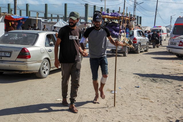 A Palestinian man wounded in an Israeli strike is helped as he walks outside a field hospital where he receives treatment, in Rafah in the southern Gaza Strip, on May 30, 2024. (Photo by Hatem Khaled/Reuters)