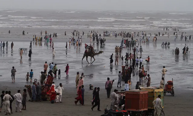 People visit Clinfton beach, during a hot summer's day in Karachi, Pakistan, Sunday, July 5, 2015. Many cities in Pakistan are facing heat wave conditions with temperatures reaching up to 47 degrees Celsius (116.6 Fahrenheit) in some places. (Photo by Fareed Khan/AP Photo)