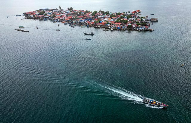 Aerial view of a motorboat moving Indigenous Guna people from Carti Sugtupu island to the mainland in Guna Yala Comarca, on the Caribbean coast in Panama, on June 03, 2024. Panamanian authorities handed over the keys to their new homes on the mainland to some 300 families from Carti Sugtupu, aka Gardi Sugdub, a small Caribbean island affected by rising sea levels, who will become Panama's first climate-displaced persons. (Photo by Martin Bernetti/AFP Photo)