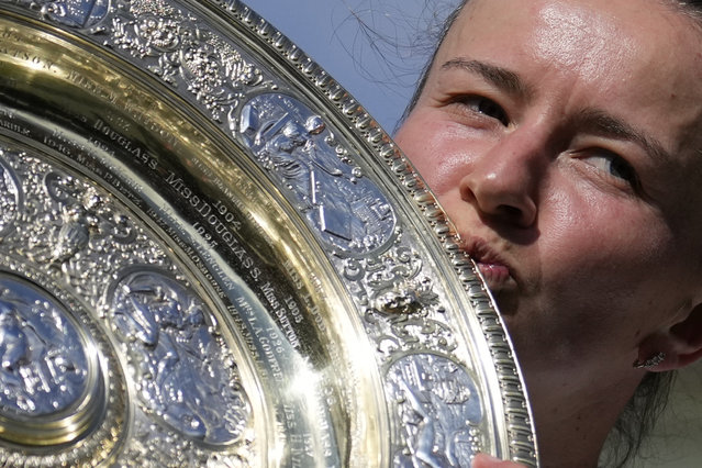 Barbora Krejcikova of the Czech Republic kisses the winners trophy for the photographers after she defeated Jasmine Paolini of Italy in the women's singles final at the Wimbledon tennis championships in London, Saturday, July 13, 2024. (Photo by Mosa'ab Elshamy/AP Photo)