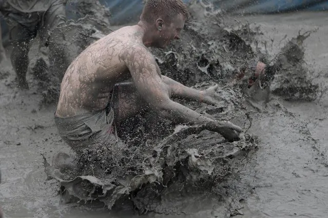 Festival-goers wrestle in the mud during the annual Boryeong Mud Festival at Daecheon Beach on July 18, 2015 in Boryeong, South Korea. (Photo by Chung Sung-Jun/Getty Images)