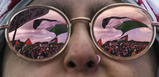 A Palestinian flag is reflected in the sunglasses of a Pro-palestinian supporter demonstrating outside Hampden Park stadium, in Glasgow, Scotland, on May 31, 2024 prior to the UEFA Women's Euro 2025 League B Group 2 qualifying football match between Scotland and Israel. (Photo by Andy Buchanan/AFP Photo)