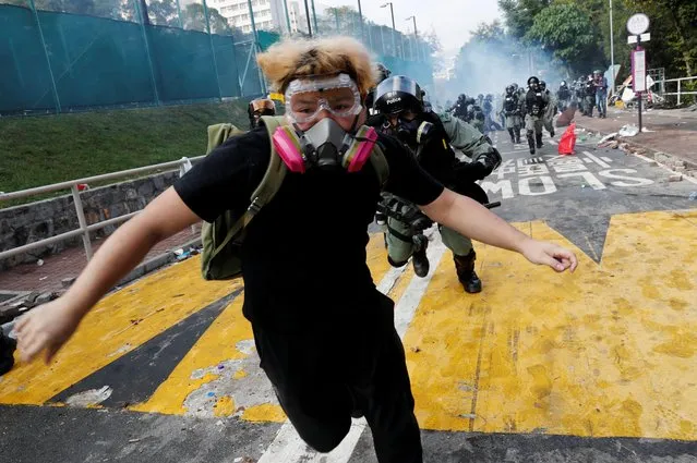 A university student runs from riot police at the Chinese University of Hong Kong, Hong Kong, China on November 12, 2019. (Photo by Tyrone Siu/Reuters)