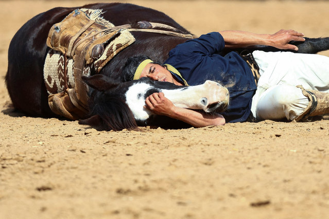 A man performs with a horse during the official opening ceremony of the 136th Rural Society's annual exposition, in Buenos Aires, Argentina on July 28, 2024. (Photo by Matias Baglietto/Reuters)