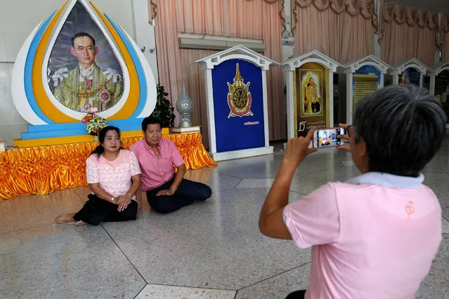 Well-wishers wear pink shirts as they pose for a photograph in front of a picture of Thailand's King Bhumibol Adulyadej at Siriraj Hospital in Bangkok, Thailand, October 11, 2016. (Photo by Chaiwat Subprasom/Reuters)