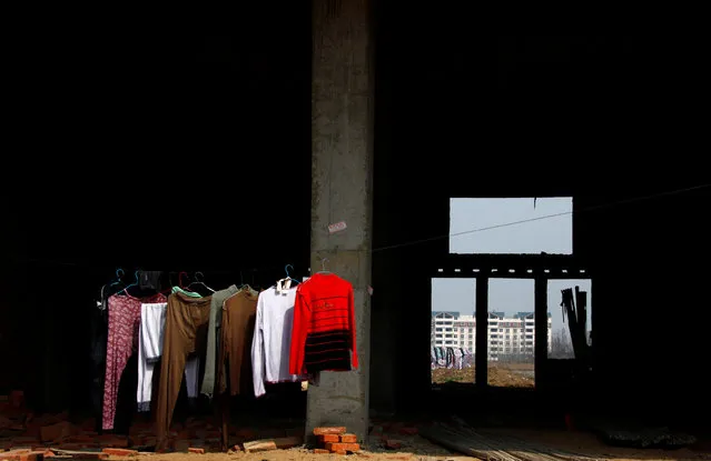Clothes hang from a line in a residential building under construction in the town of Gushi in Henan Province, March 28, 2010. (Photo by David Gray/Reuters)