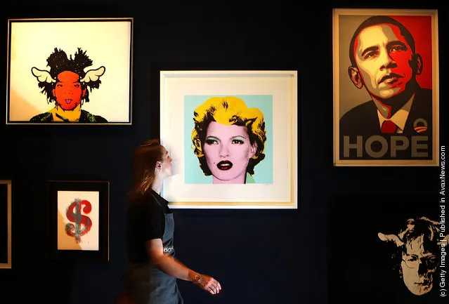 Employee Victoria Livesey walks past Banksy's 'Kate Moss 2005' on display at Bonhams