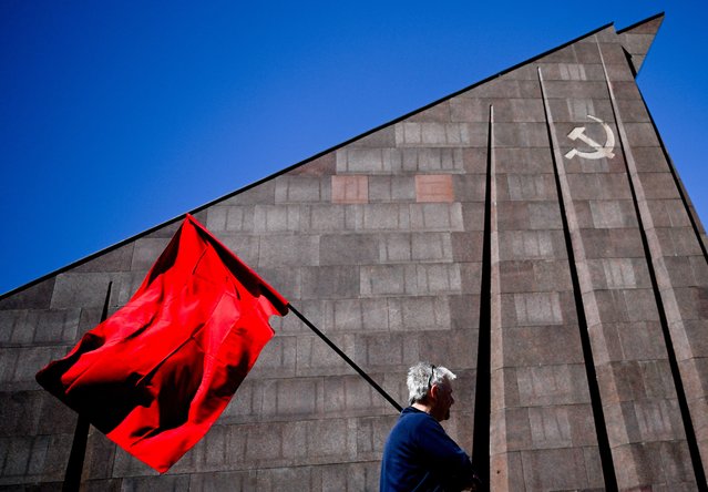 A man walks with red flag at the Soviet World War II memorial in Treptow park, Berlin, Germany, 08 May 2023. World War II ended by the unconditional surrender of Nazi Germany on all fronts on 09 May 1945. (Photo by Filip Singer/EPA)