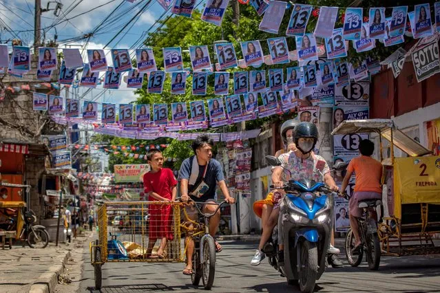 A street filled with campaign posters is seen a day before 67 million Filipinos head to the polls to elect a new set of leaders, on May 08, 2022 in Quezon city, Metro Manila, Philippines. The son and namesake of ousted dictator Ferdinand Marcos Sr., who was accused and charged of amassing billions of dollars of ill-gotten wealth as well as committing tens of thousands of human rights abuses during his autocratic rule, has mounted a hugely popular campaign to return his family name to power. Ferdinand "Bongbong" Marcos Jr. enjoys a wide lead in opinion polls against his main rival, Vice President Leni Robredo, owing to a massive disinformation campaign that has effectively rebranded the Marcos dictatorship as a “golden age”. Marcos is running alongside Davao city Mayor Sara Duterte, the daughter of outgoing President Rodrigo Duterte who is the subject of an international investigation for alleged human rights violations during his bloody war on drugs. (Photo by Ezra Acayan/Getty Images)