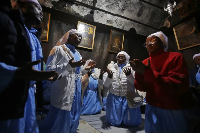 Christian pilgrims pray in the Grotto of the Church of the Nativity on Christmas Eve in the biblical West Bank city of Bethlehem on December 24, 2019. (Photo by Musa Al Shaer/AFP Photo)