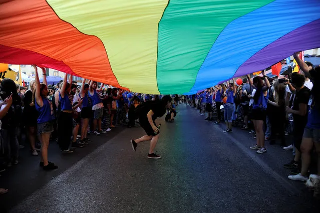 Gay rights activists raise a huge rainbow flag during a gay pride parade in Athens, June 11, 2016. (Photo by Michalis Karagiannis/Reuters)