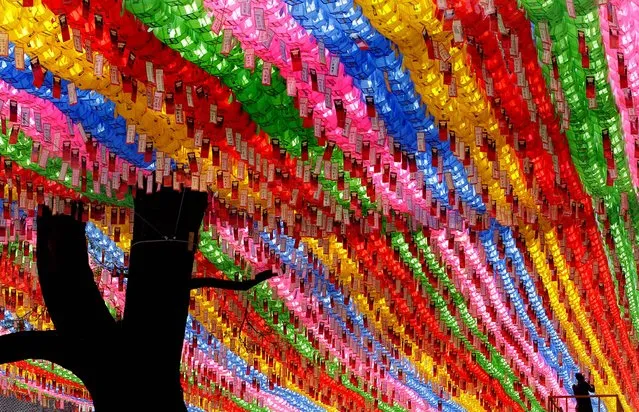 A worker attaches devotees' name tags with their wishes on lanterns in preparation for the birthday celebration of Buddha, which falls on May 28, at Jogye temple in Seoul, South Korea