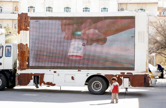 A Yemeni child stands by a truck showing an advertising of launching an anti-polio vaccination campaign on December 23, 2019 in Sana'a, Yemen. A widespread vaccination campaign has launched on Monday and supported by the World Health Organization (WHO) and the United Nations Children's Fund (UNICEF), targeting more than 5.5 million children under the age of five. The campaign is a home-to-home and will continue for three days. (Photo by Mohammed Hamoud/Getty Images)