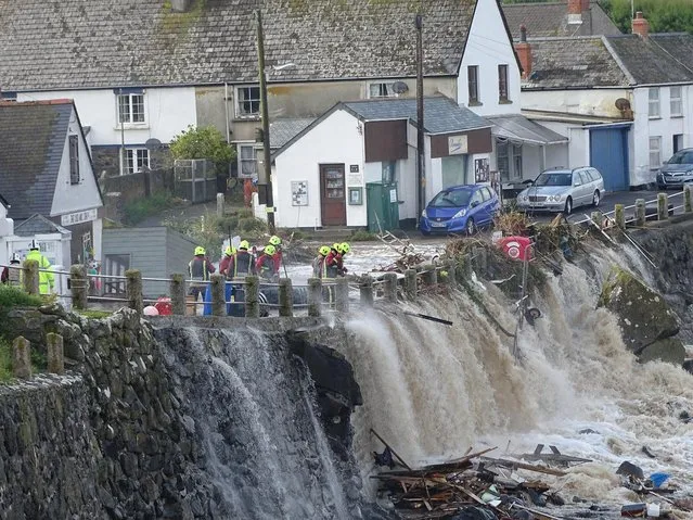 Emergency services work on the scene of flash flooding in Coverack, England, Tuesday, July 18, 2017. British authorities say major flash flooding has hit a coastal village in the English county of Cornwall, prompting a rescue operation. The coast guard says six people were trapped in a house and one of its helicopters has rescued two of them. No injuries have been reported and no further details given. (Photo by ITV)