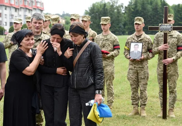Mourners including relatives gather during the funeral ceremony of slain Ukrainian serviceman Ruslan Skalskyi at Lychakiv cemetery in the western Ukrainian city of Lviv, on June 11, 2022, amid the Russian invasion of Ukraine. (Photo by Yuriy Dyachyshyn/AFP Photo)