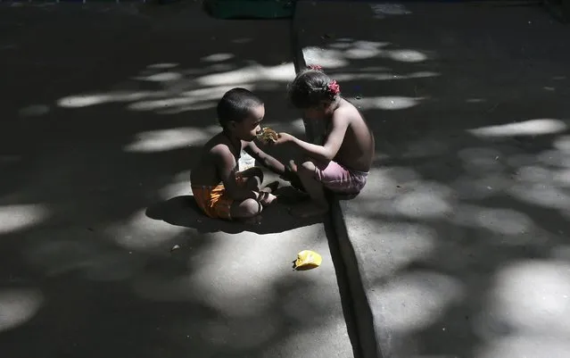 A girl feeds her brother in a slum area under a flyover in Kolkata, India, June 29, 2016. (Photo by Rupak De Chowdhuri/Reuters)