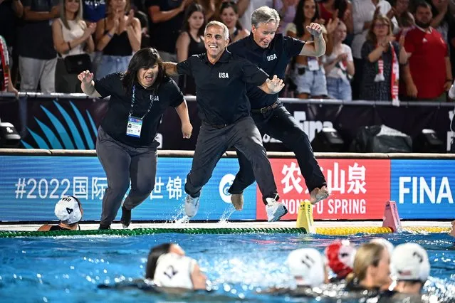 The US coaching team leap into the pool after their players beat Hungary in the women's world waterpolo final in Budapest on July 2, 2022. (Photo by Marton Monus/Reuters)