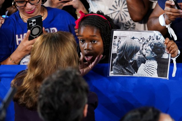 A child reacts while holding a picture of her and Kamala Harris as Harris speaks to her during Harris' campaign rally, in Houston, Texas on October 25, 2024. (Photo by Kevin Lamarque/Reuters)
