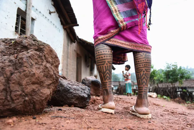 For more than 2,000 years, women from the Baiga tribe in the highland district of Dindori, in central India’s Madhya Pradesh state, have been tattooed. Sumintra, 25, from Bona village, has the markings across her forehead, legs and arms. The women who work as tattoo artists are knowledgable about the different types of designs and pigments preferred by various tribes, and their meanings are passed to them by their mothers. The tattooing ‘season’ begins with the approach of winter. (Photo by Ronny Sen/WaterAid/The Guardian)