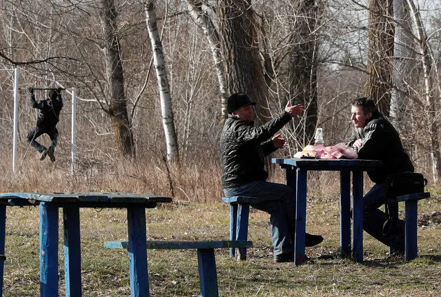 Men talk as they share a meal in the village of Novi Sanzhary, where the evacuees from coronavirus-hit China's Hubei province are quarantined at a sanatorium, in Poltava region, Ukraine on February 21, 2020. (Photo by Valentyn Ogirenko/Reuters)