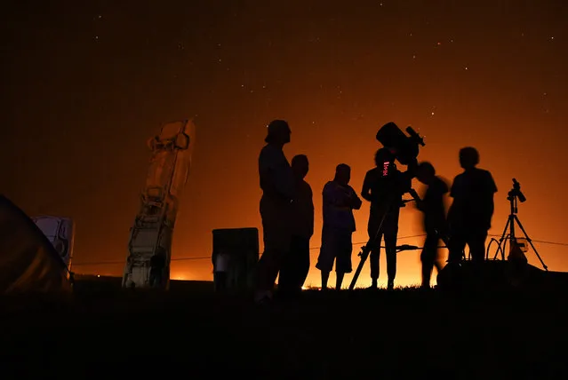 Stargazers watch the night sky as they camp near Carhenge on August 20, 2017 in Alliance, Nebraska. People are gathering near Carhenge to watch the upcoming total solar eclipse. (Photo by RJ Sangosti/The Denver Post)